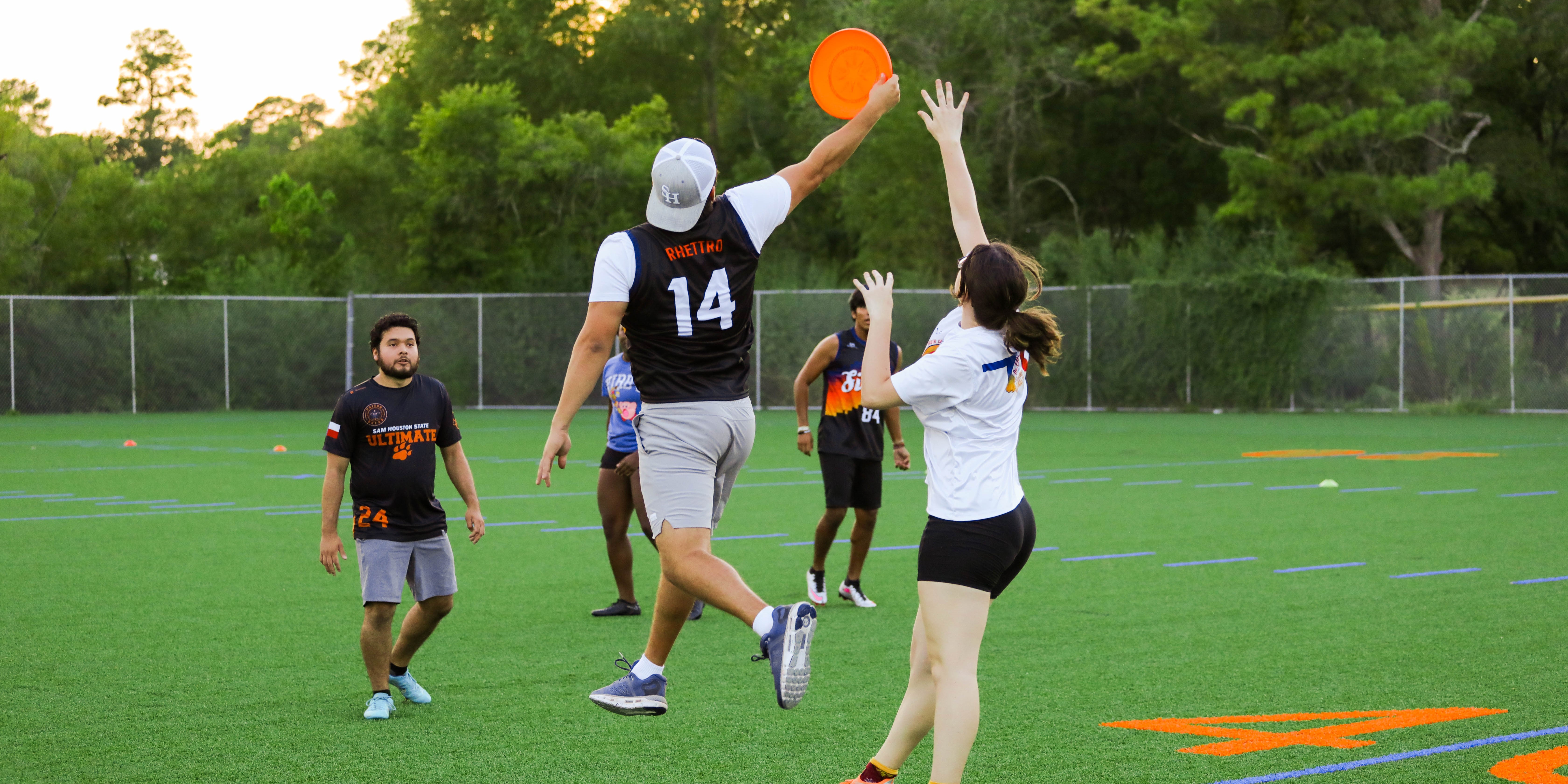 guy and girl jumping for frisbee